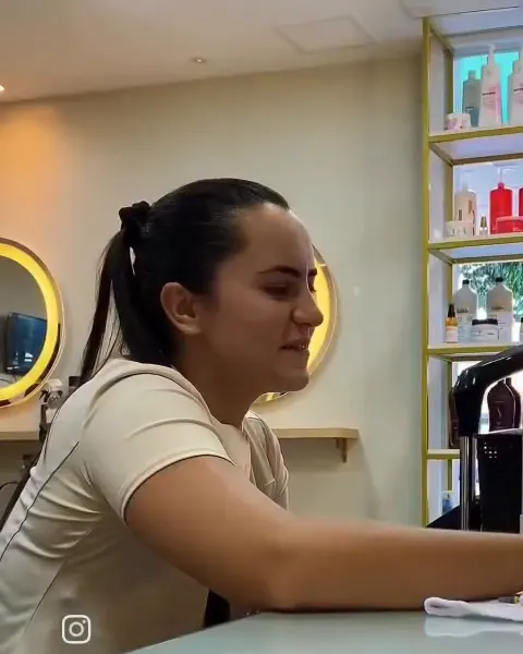 Profissional sorrindo, atendendo na bancada do salão
